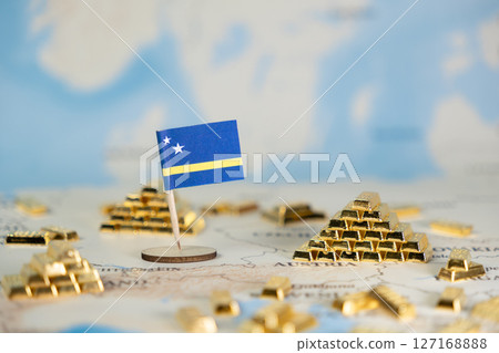 Miniature Curacao national flag prominently displayed on a world map, surrounded by scattered shiny gold bars, symbolizing national economy and global investment prospects 127168888
