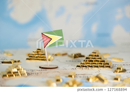 Guyana flag alongside shining gold bars on a world map, representing national wealth, natural resources, and investment potential with copy space 127168894