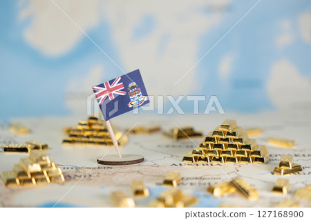 Cayman Islands flag and gleaming gold bars positioned on a detailed world map, symbolizing offshore finance, international investment, and global wealth management 127168900