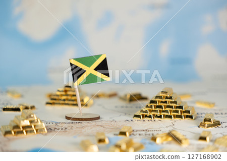 Jamaican flag on a world map, surrounded by stacks of gleaming gold bars, symbolizing national economic strength, global investment, and valuable financial assets 127168902