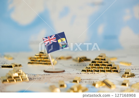 Saint Helena flag with miniature gold bars on map symbolizing overseas financial status, historical wealth, and investment potential of this British island territory 127168908