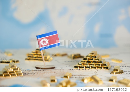 North Korean flag proudly displayed on a world map, surrounded by gleaming gold bar stacks, symbolizing national wealth, economic power, and global finance 127168912