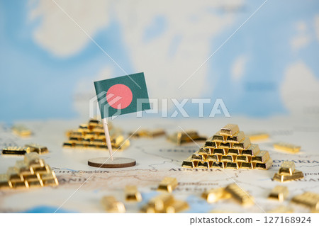 Bangladesh flag and miniature gold bar stacks on a world map symbolize global economic prosperity, national wealth, international trade, and investment strategy 127168924