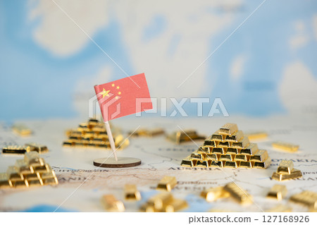 Chinese flag stands prominently on world map, surrounded by gleaming gold bars, representing global financial influence, wealth accumulation, and strategic investment, offering ample copy space 127168926