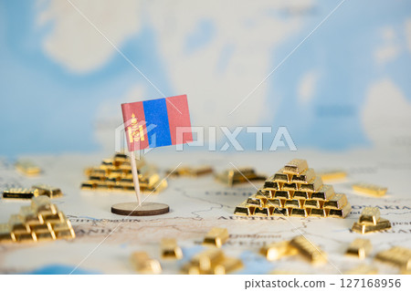 Small Mongolian flag and numerous gold bars on a world map symbolize national resource wealth, economic power, and global finance 127168956