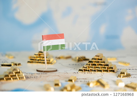 Hungarian flag prominently displayed on a global map, surrounded by glistening gold bar stacks, symbolizing national wealth, economic stability, and international finance 127168968
