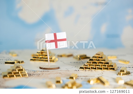 England flag and numerous gold bar stacks on a world map, symbolizing national wealth, economic power, and global investment, with copy space 127169011