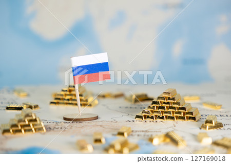 Russian flag prominently stands on a world map with gold bar stacks, symbolizing national wealth, global economic influence, and resource management, offering copy space 127169018