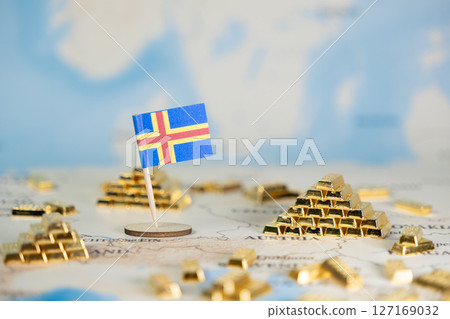 Aland Islands flag on world map with stacked gold bars, symbolizing national wealth, global economic stability, and financial investment, offering ample copy space 127169032