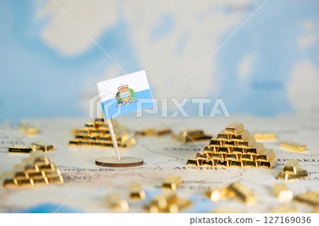 San Marino flag on global map beside shining gold bar pyramids, symbolizing national economic prosperity, financial investment, wealth, and global trade, with copy space 127169036