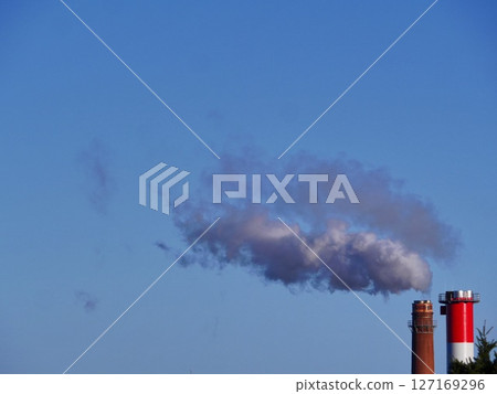 A large cloud of smoke is rising from a red and white tower 127169296