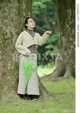 一名日本婦女在樹下避雨 127169355