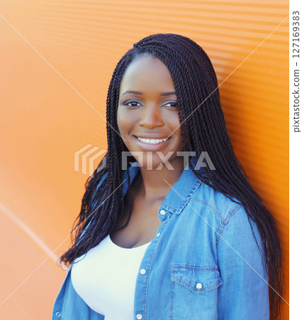 Portrait of happy stylish young African woman, black girl smiling posing in the city Portrait of happy stylish young African woman, black girl smiling posing in the city 127169383