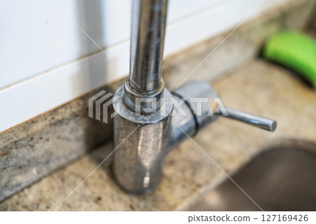 Dirty kitchen sink faucet contaminated with calcium and dirt. 127169426