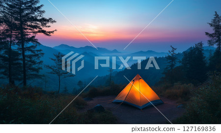 籠罩在紫色暮色中的山區和一頂亮著燈的單人露營帳篷 127169836