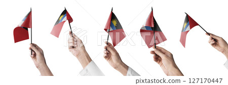 The Antigua and Barbuda flag in hand in different angles on a white background The Antigua and Barbuda flag in hand in different angles on a white background 127170447