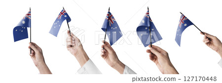 The Australia flag in hand in different angles on a white background 127170448