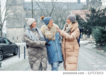 Three cheerful young adult women friend walk Magdeburg street old european uk german town city street enjoy having fun laughing cold winter day together. Female persons friendship celebration weekend Three cheerful young adult women friend walk Magdeburg street old european uk german town city street enjoy having fun laughing cold winter day together. Female persons friendship celebration weekend 127171013