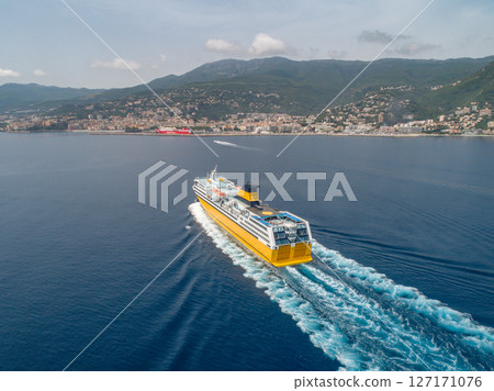 Big yellow passenger ferry goes on the Mediterranean Sea near Corsica island, France aerial view Cityscape Bastia port 127171076
