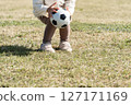Child holding a soccer ball on the grass 127171169