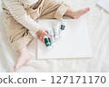 A child holding paint and a white canvas 127171170