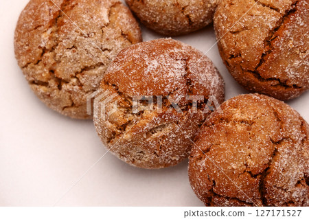 Baked ginger snap cookies with cracked crumbly texture on ceramic plate. Macro shot. Baked ginger snap cookies with cracked crumbly texture on ceramic plate. Macro shot. 127171527