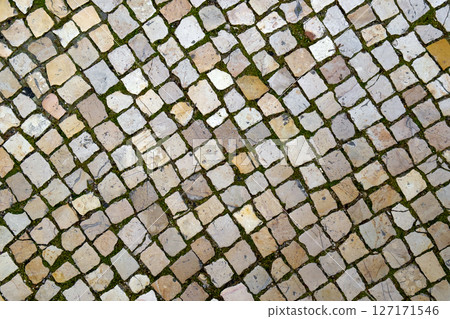 Cobblestone road surface of portuguese city street sidewalk. Top view. Abstract paving stone background Cobblestone road surface of portuguese city street sidewalk. Top view. Abstract paving stone background 127171546