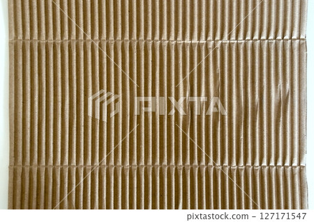 Corrugated brown packaging cardboard paper on white table. Abstract background Corrugated brown packaging cardboard paper on white table. Abstract background 127171547