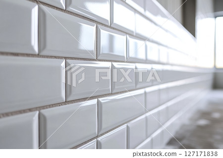 Ceramic tiles with a glossy finish and beveled edges set into horizontal brickwork. The sleek and clean wall design is ideal for kitchens and bathrooms with a minimalist or modern aesthetic. Banner Ceramic tiles with a glossy finish and beveled edges set into horizontal brickwork. The sleek and clean wall design is ideal for kitchens and bathrooms with a minimalist or modern aesthetic. Banner 127171838