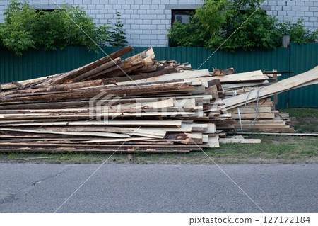 Pile of Rough Wood Boards at Street for Building 127172184
