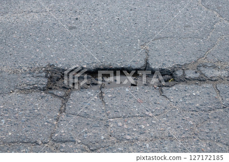 Pothole and Cracks on an Asphalt Road 127172185