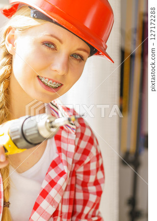 Woman using drill to fix or installing windows 127172288