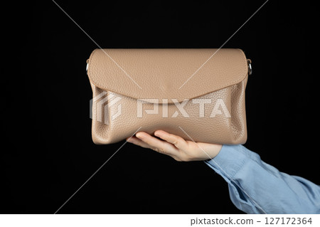 Small leather women's handbag in hand, copy space for text 127172364