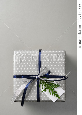 Silver polka dot gift box with silver and dark blue ribbon. Vertical banner, space for your text. Silver polka dot gift box with silver and dark blue ribbon. Vertical banner, space for your text. 127172556