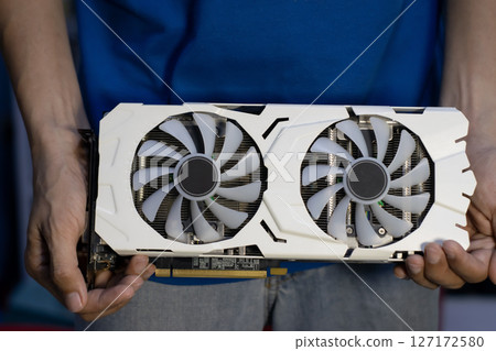 Front view of white graphics card, computer parts, technician holding graphics card 127172580