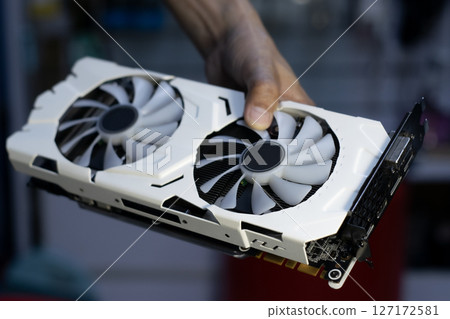 Side of white graphics card, computer parts, technician holding graphics card Side of white graphics card, computer parts, technician holding graphics card 127172581