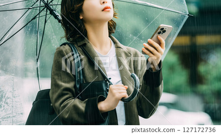 一名女子在傘下使用智慧型手機(雨季,六月) 一名女子在傘下使用智慧型手機(雨季,六月) 127172736