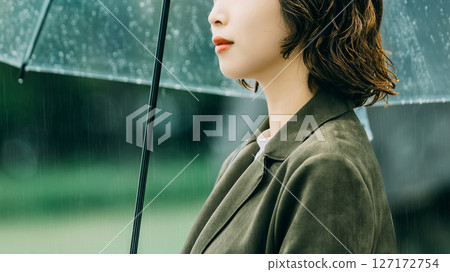 A woman holding an umbrella in the rain (rainy season, June) 127172754
