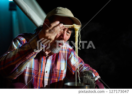 Solo camper eating ramen for midnight snack Solo camp Senior Solo camper eating ramen for midnight snack Solo camp Senior 127173047