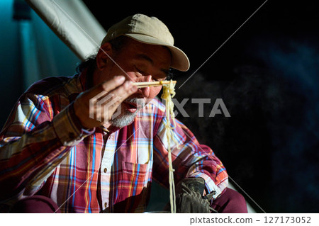 Solo camper eating ramen for midnight snack Solo camp Senior 127173052