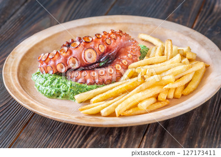 Baked Octopus With Creamy Spinach And Fries On A Rustic Plate Baked Octopus With Creamy Spinach And Fries On A Rustic Plate 127173411