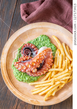 Baked Octopus With Creamy Spinach And Fries On A Rustic Plate Baked Octopus With Creamy Spinach And Fries On A Rustic Plate 127173413