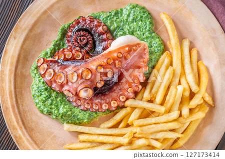 Baked Octopus With Creamy Spinach And Fries On A Rustic Plate 127173414