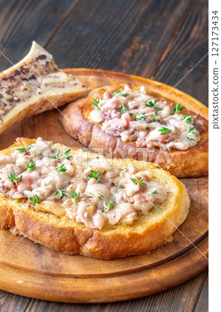 Toasted marrow sandwiches garnished with thyme served on crusty golden bread slices 127173434