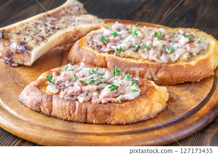 Toasted marrow sandwiches garnished with thyme served on crusty golden bread slices Toasted marrow sandwiches garnished with thyme served on crusty golden bread slices 127173435
