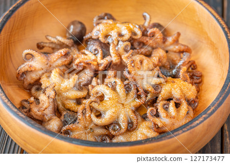 Golden Fried Garlic Octopuses Served In Rustic Wooden Bowl With Crisp Edges Golden Fried Garlic Octopuses Served In Rustic Wooden Bowl With Crisp Edges 127173477