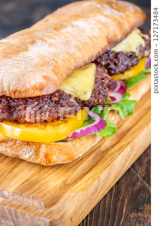 Hearty Ciabatta Sandwich Stacked With Beef Patties, Yellow Tomatoes, And Crisp Lettuce 127173484