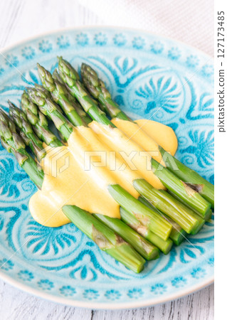 Blue Plate of Boiled Asparagus Drizzled in Silky Hollandaise Sauce 127173485