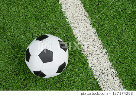 Soccer Ball on Green Grass Field with White Line. Football stadium background. View from above. 127174298