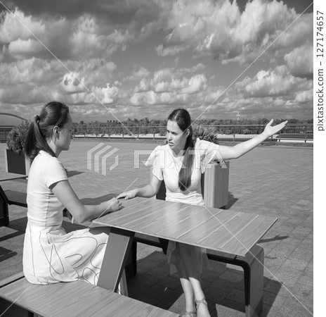 Girls arguing in a cafe Girls arguing in a cafe 127174657